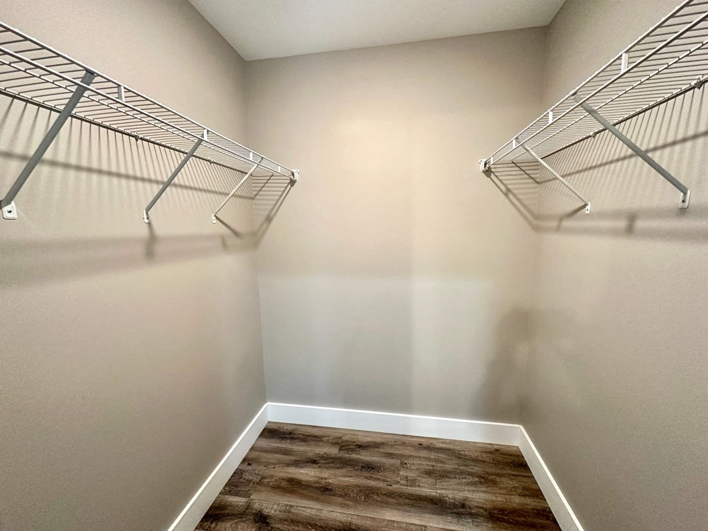 a spacious walk in closet in a home with a mirrored wall