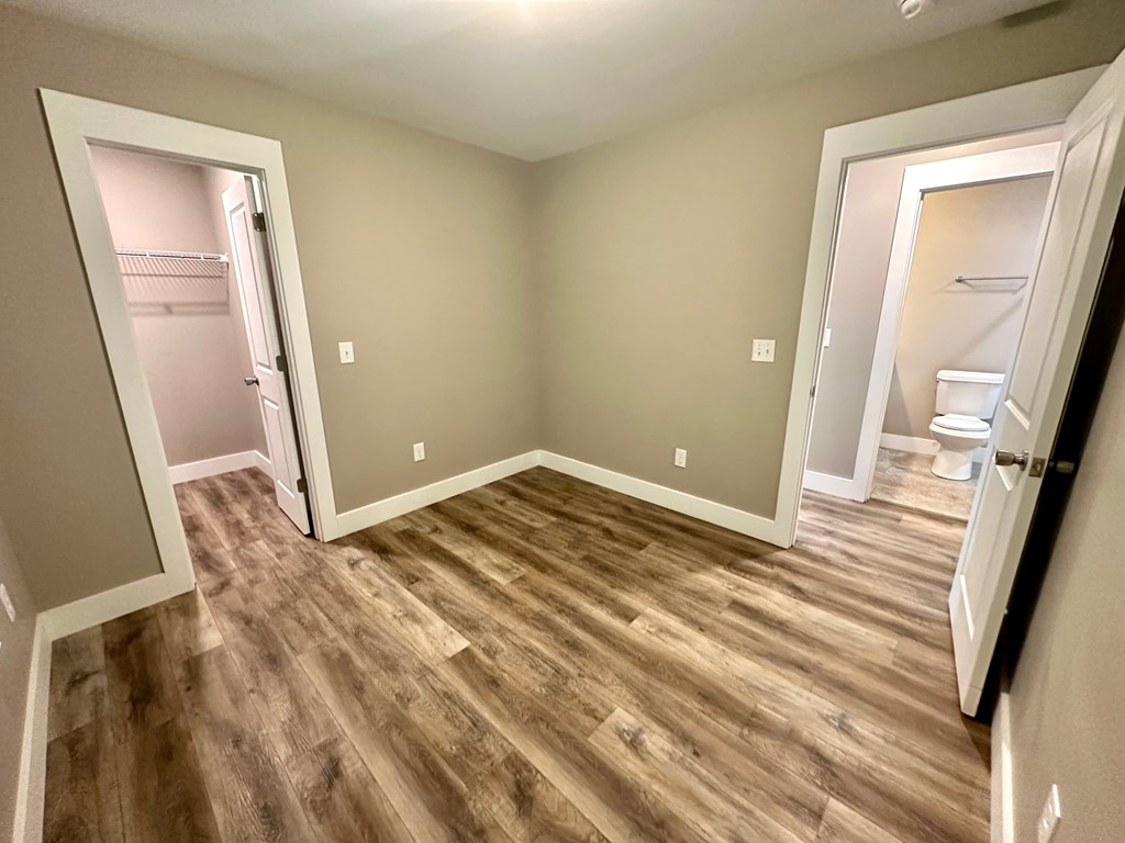 a empty room with a bathroom and a door to a closet