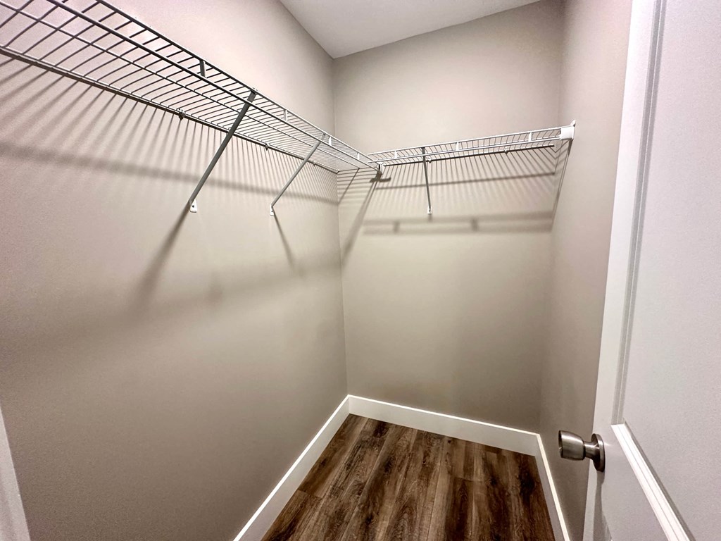 a spacious walk in closet with a wire closet rack