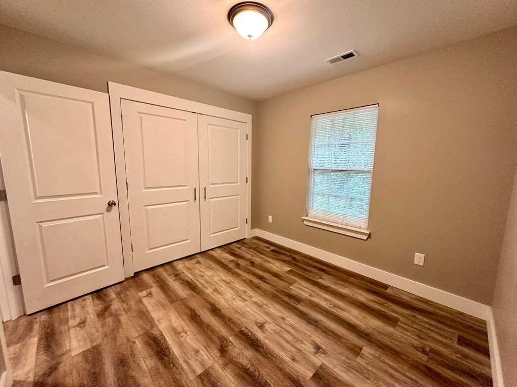 an empty living room with a window and two doors