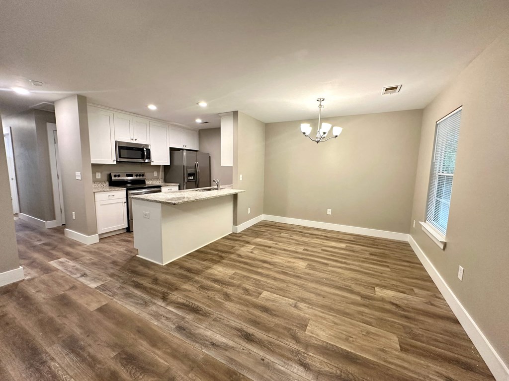 a kitchen and a living room with wood flooring