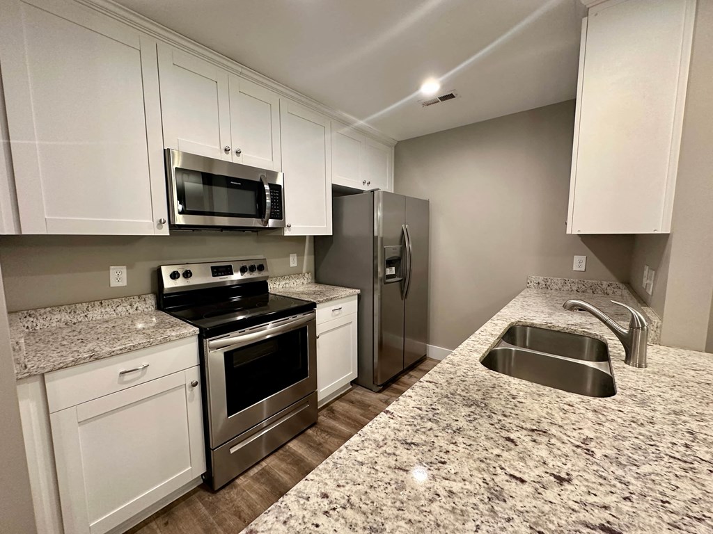 a kitchen with granite counter tops and stainless steel appliances