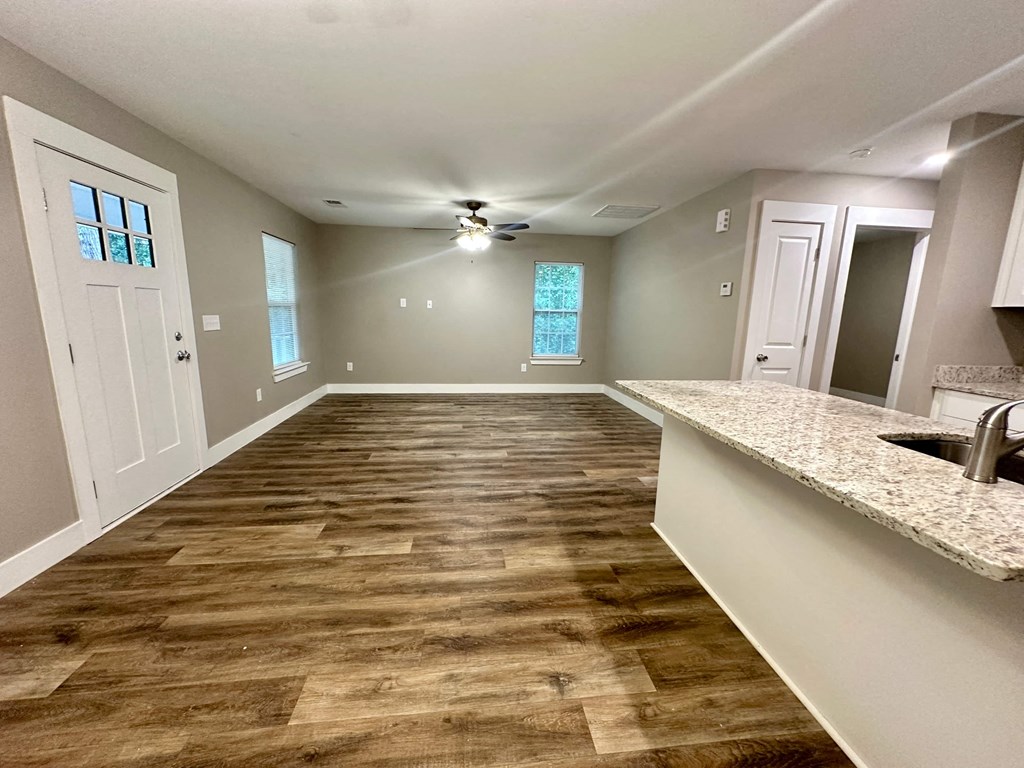 an empty kitchen and living room with a hard wood floor