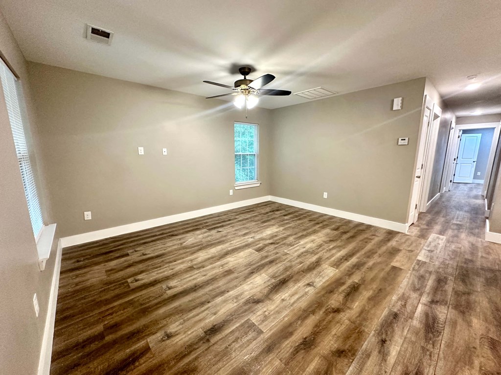 a living room with hard wood floors and a ceiling fan