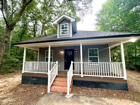 a small house with a porch and a porch swing