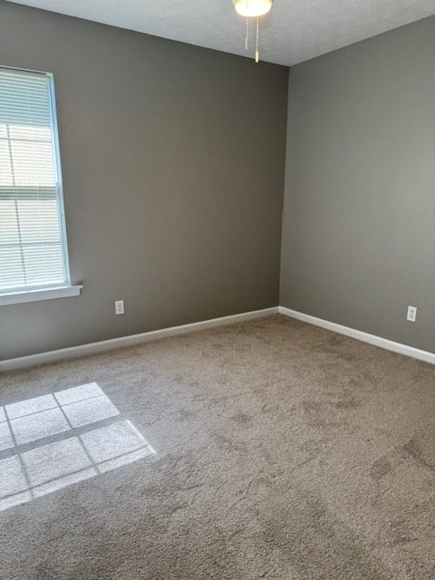 an empty room with a window and a carpeted floor
