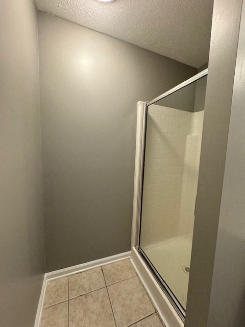 a bathroom with a shower and a tiled floor