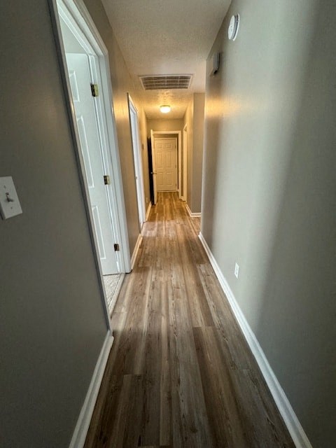 a long hallway with wood floors and a door