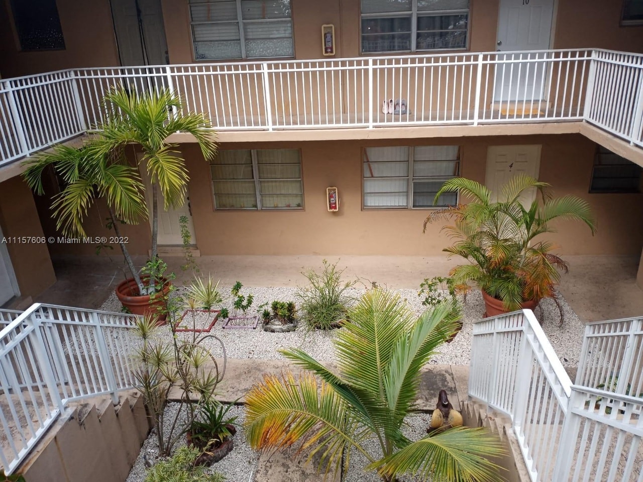 an aerial view of a building with a balcony and palm trees