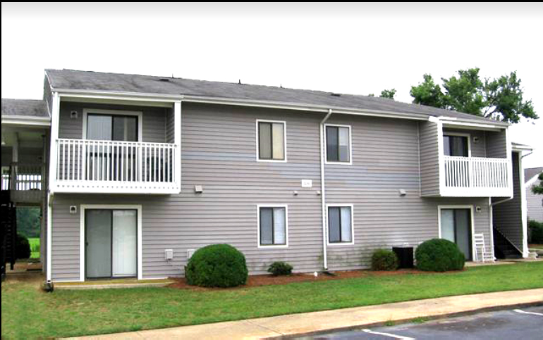 the exterior of an apartment building with a porch and balconies