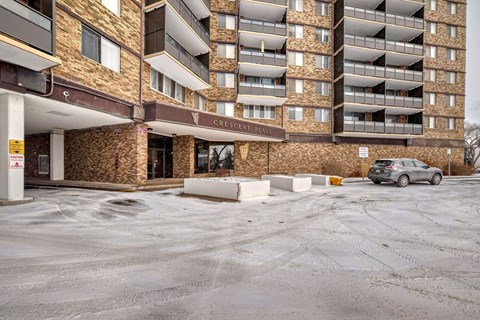 an empty parking lot in front of a large apartment building