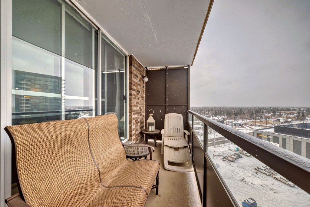 a balcony with two chairs and a view of a city