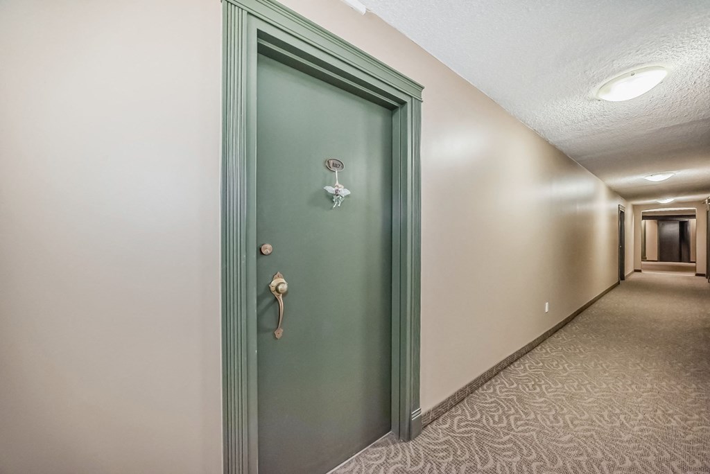 a room with a green door in the middle of a hallway