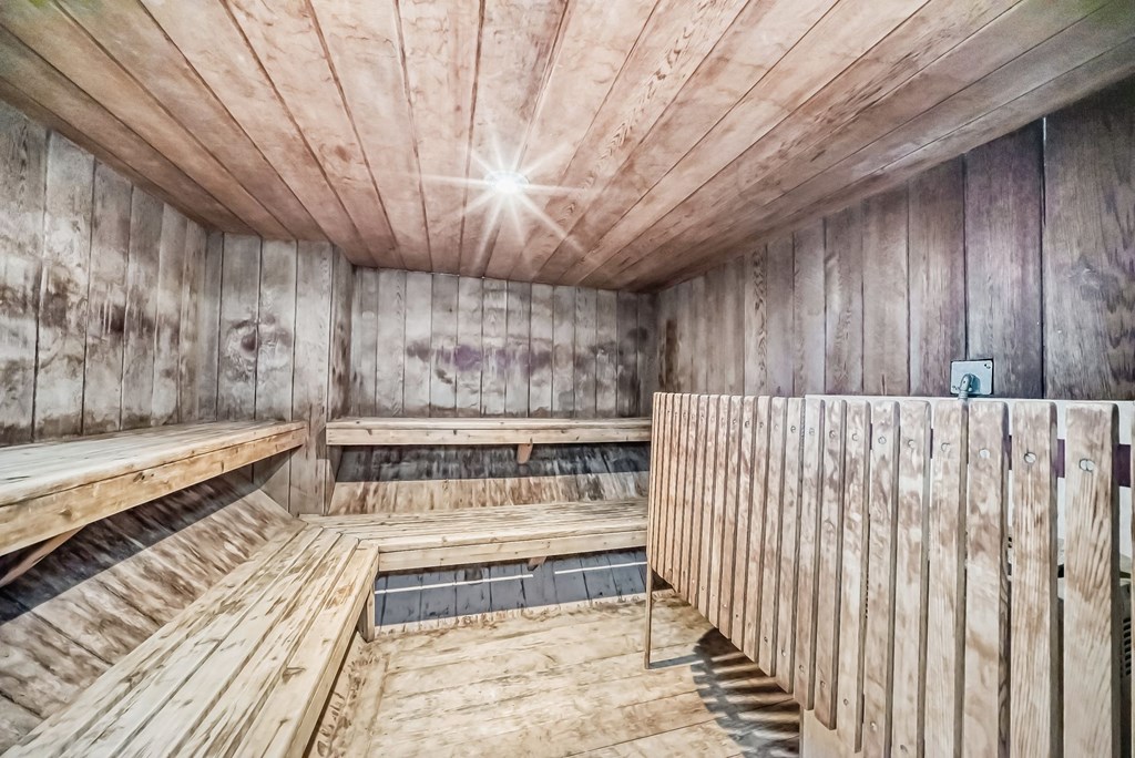 a sauna with wooden floors and walls and a pool