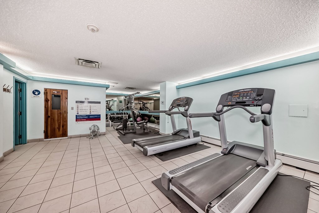two treadmills and other exercise equipment in the gym at the courtyard