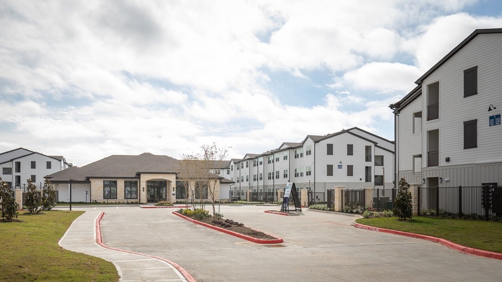 the view of a parking lot with apartments in the background
