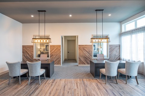 a dining room with a table and chairs and two chandeliers