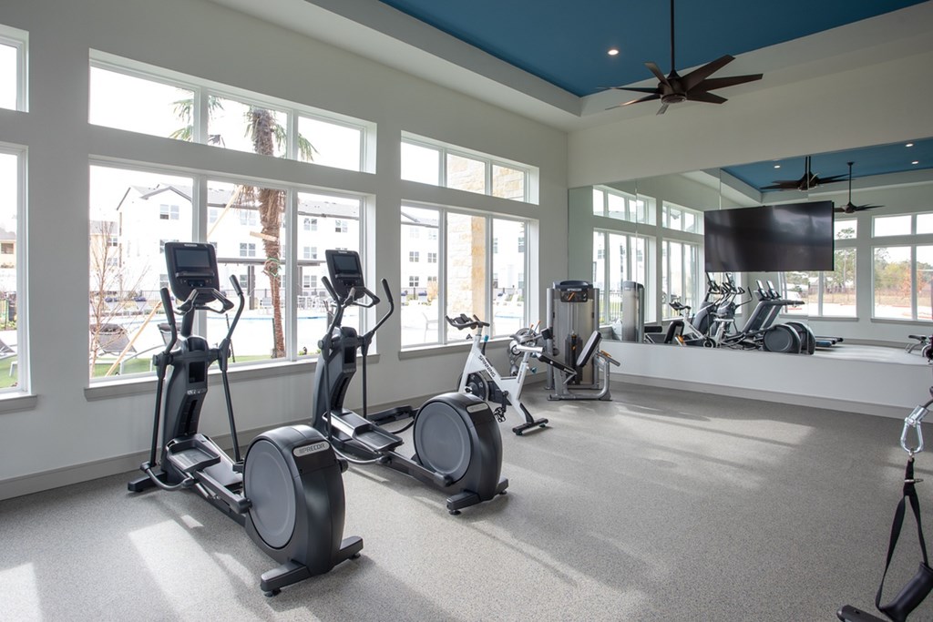 a gym with exercise bikes and a large window