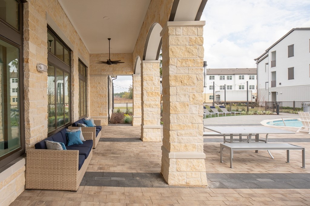 a covered patio with furniture and a pool in a building