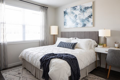 a bedroom with a bed and a desk with a chair