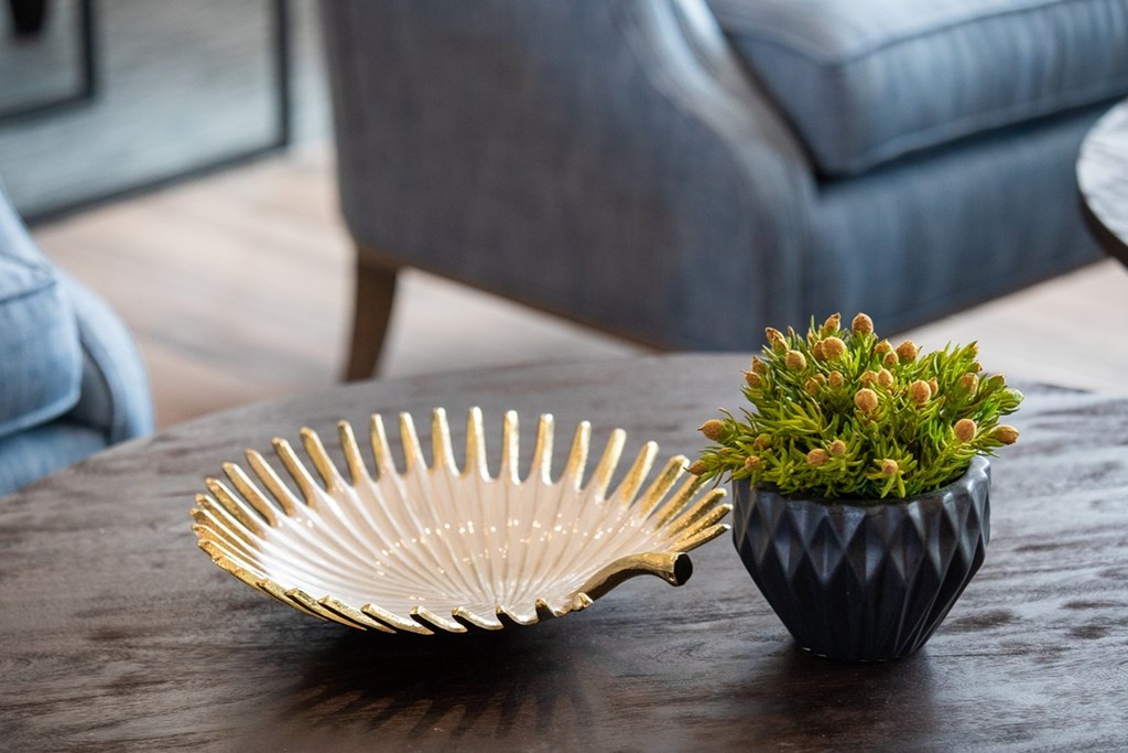 a living room with a plant and a fan on a table
