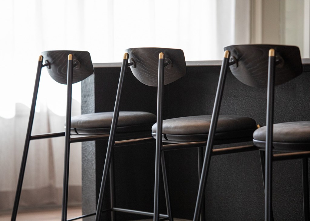 a row of black stools in front of a table