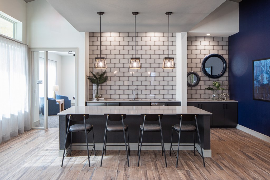 a kitchen with a white brick wall and a table with four chairs