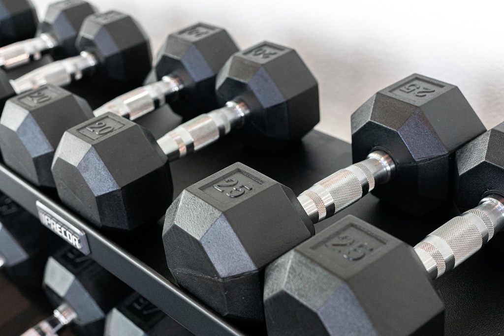 a pile of dumbbells on a weights rack