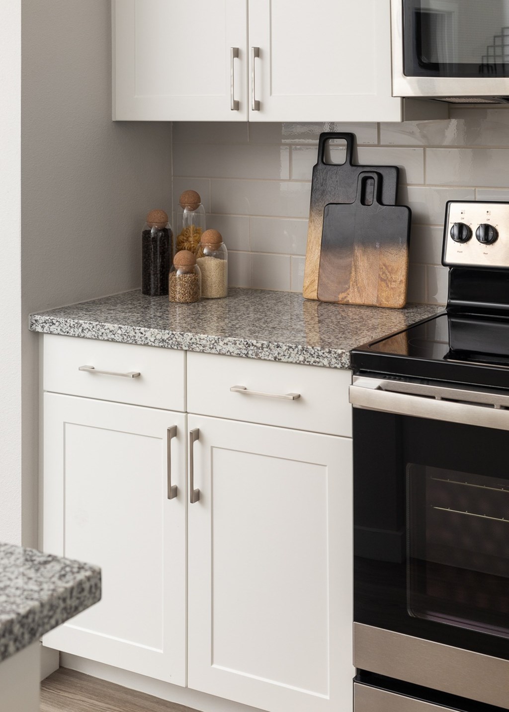 a kitchen with white cabinets and granite counter tops
