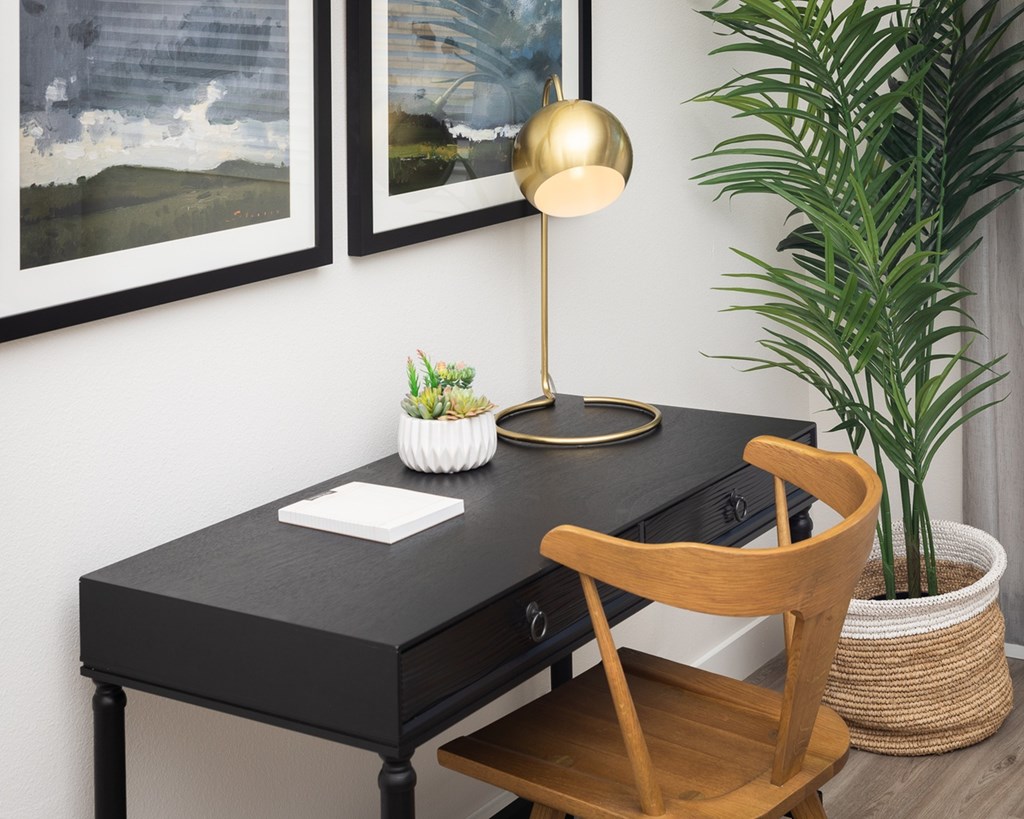 a desk with a chair and a plant in a room