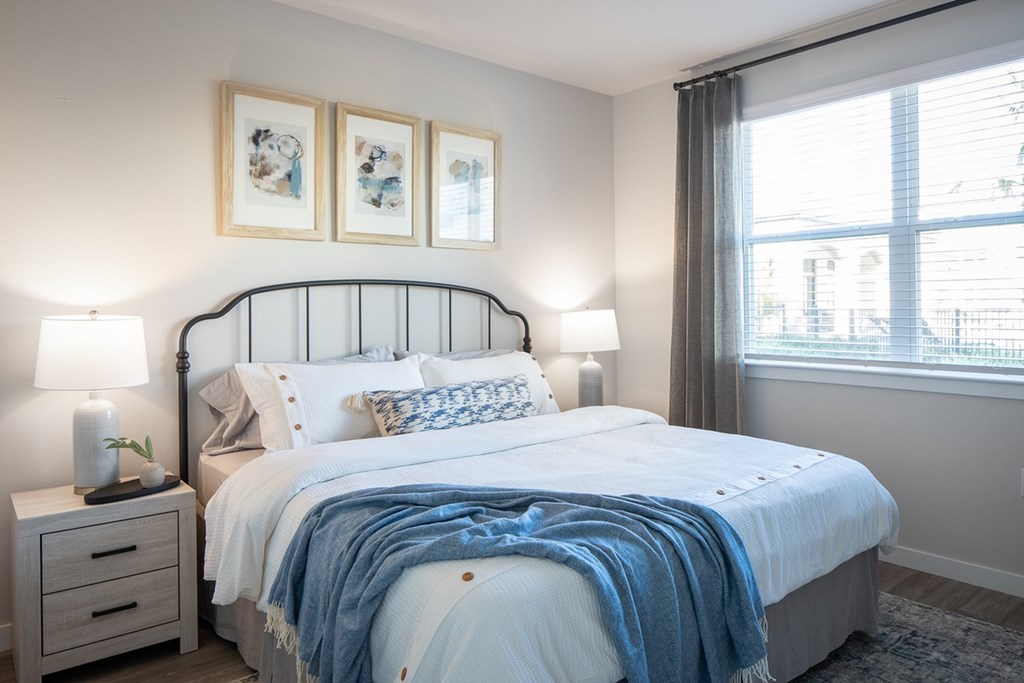 a bedroom with a bed and two windows