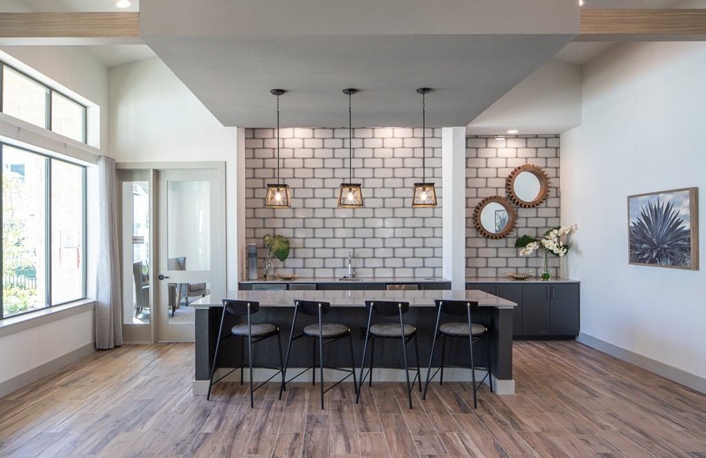 a dining room with a black table and chairs and a white brick wall