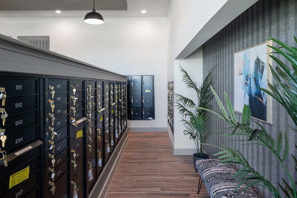 a long hallway with lockers and a plant