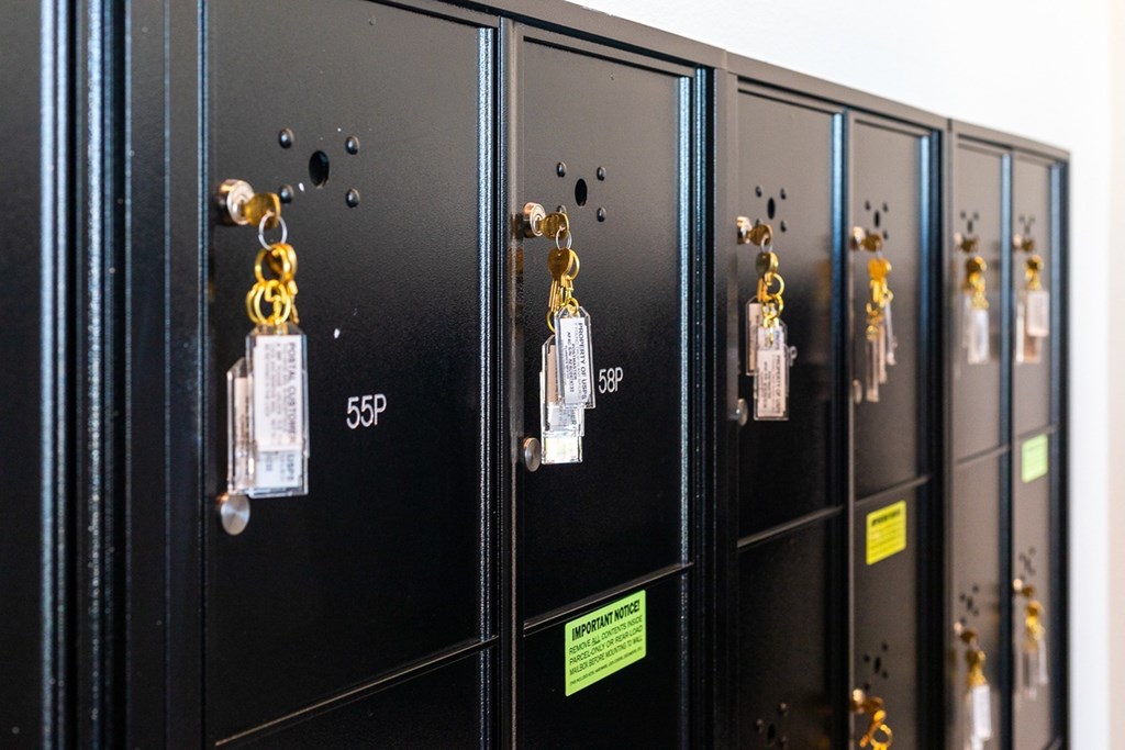a row of black lockers with keys on the door