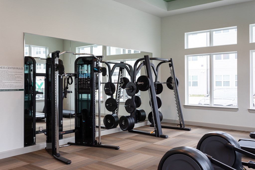 a gym with weights and mirrors in a building