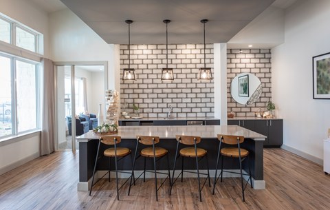 a kitchen with a white brick accent wall and a marble counter top