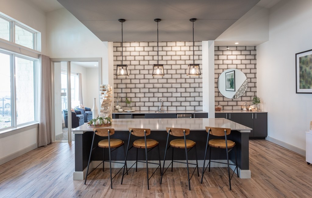 a kitchen with a white brick accent wall and a marble counter top