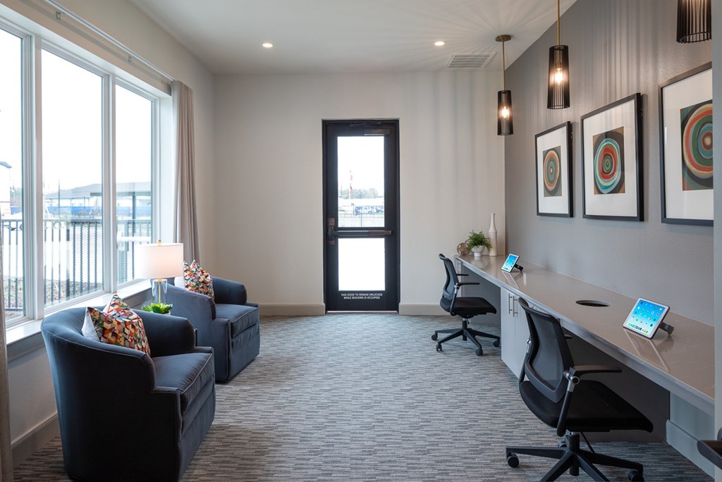 a conference room with a desk and chairs and a window