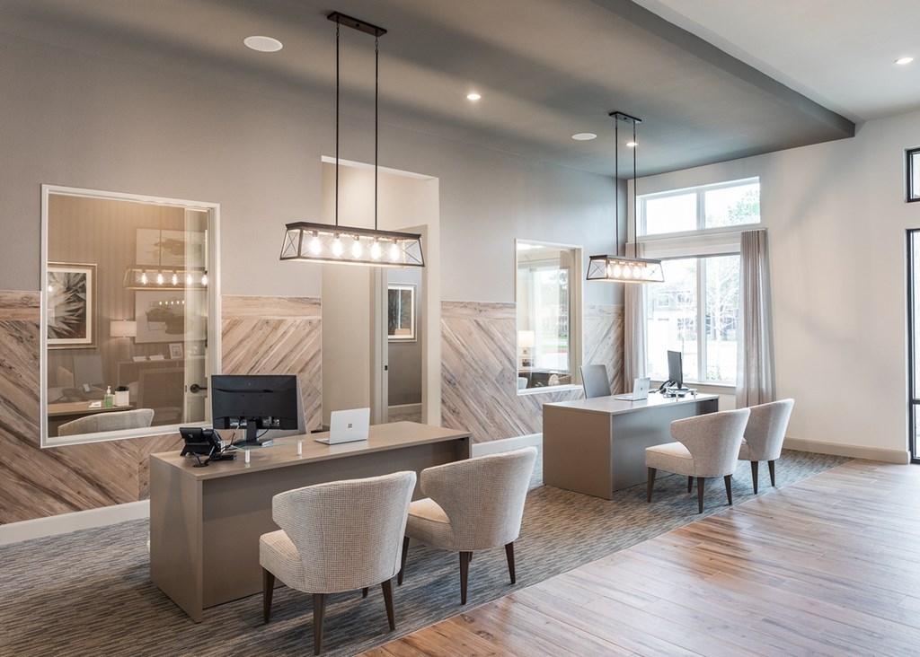 a reception area with chairs and a desk with a computer