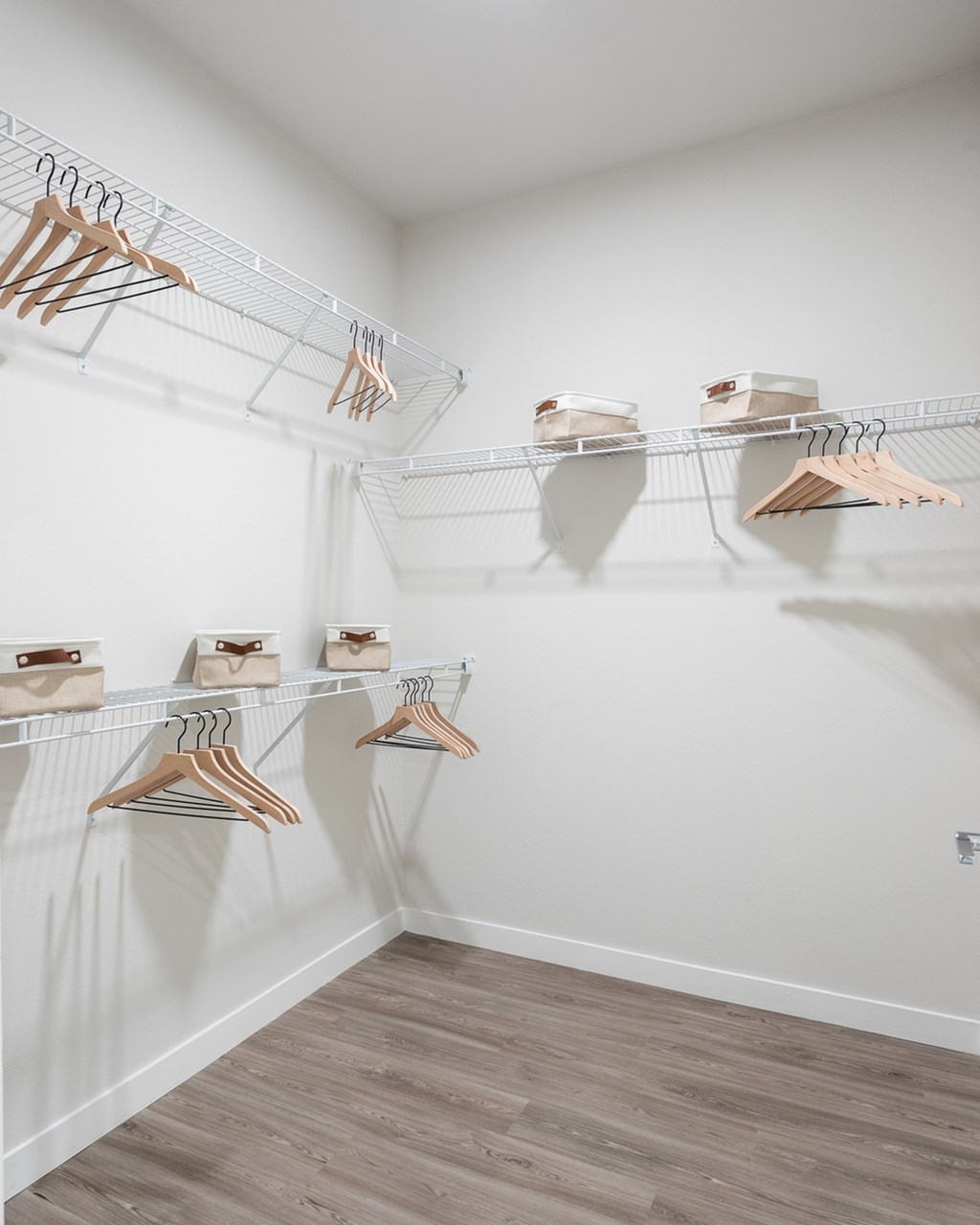 a walk in closet with shelves and hangers on the wall
