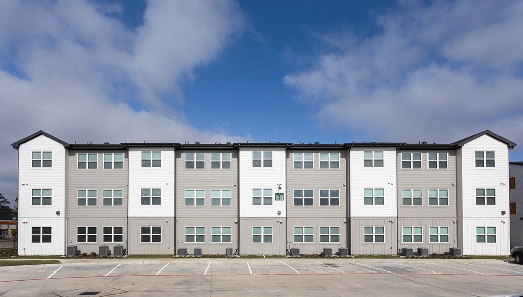 a row of apartment buildings in a parking lot
