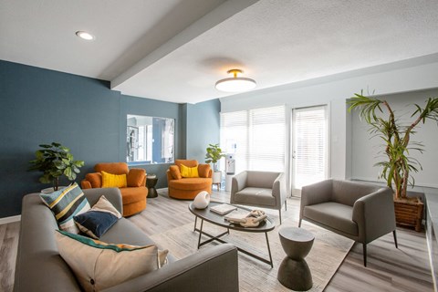 a living room with blue walls and orange couches and chairs
