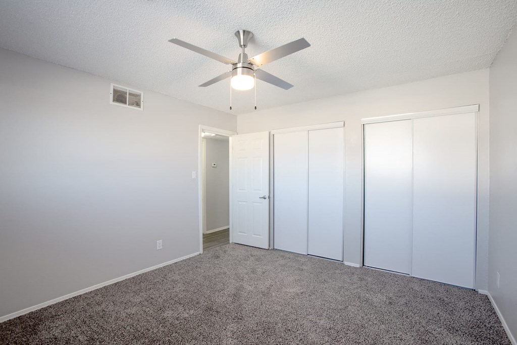 a bedroom with carpet and a ceiling fan