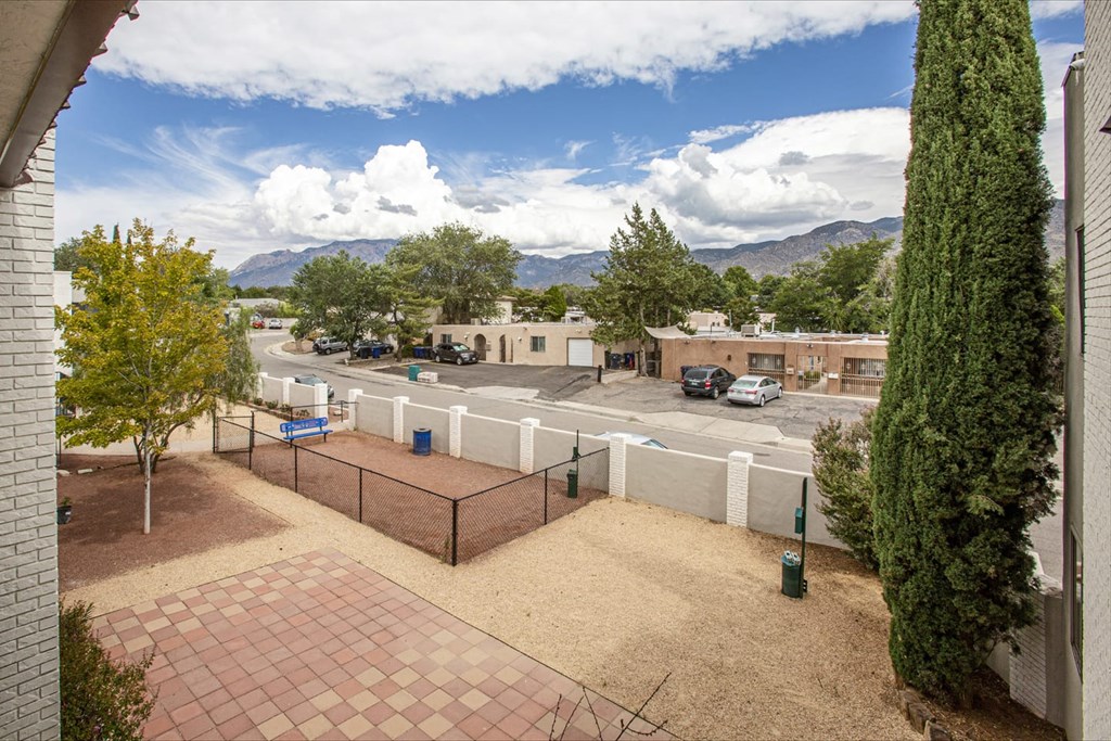 a courtyard with a tennis court and a fence