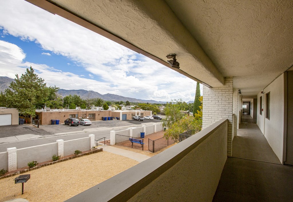 a balcony with a view of a parking lot and a building