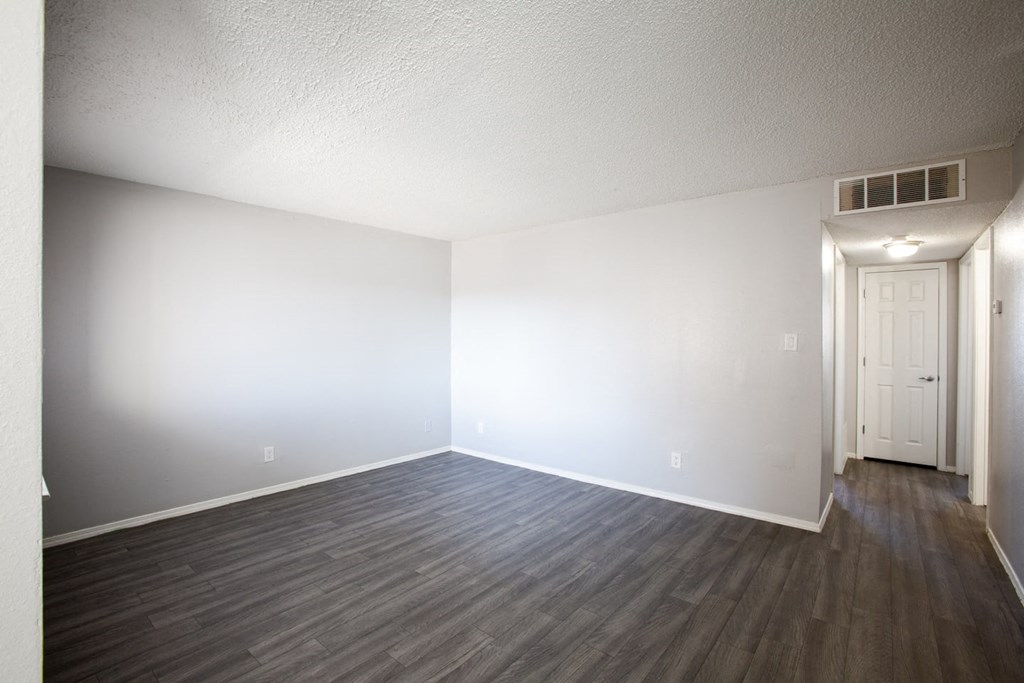 an empty living room with white walls and wood floors