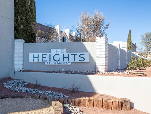 a sign for the heights in front of a white fence