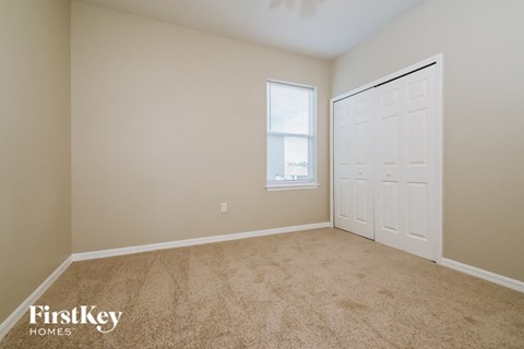 a bedroom with a closet and a door and a window