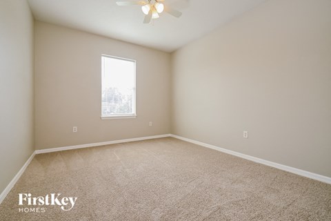 a spacious room with carpet and a window
