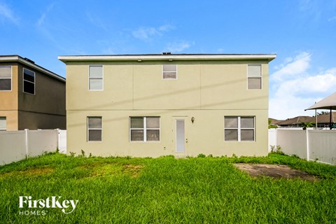 a yellow house with a grass yard in front of it